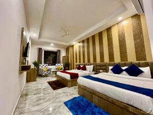 a hotel room with two beds and a couch at Hotel LA Meridian, A Luxury Hotel In Haridwar in Haridwār