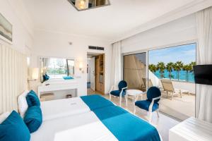 a bedroom with a bed and a view of the ocean at Vrissiana Boutique Beach Hotel in Protaras