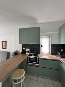a kitchen with green cabinets and a counter top at Serene appartment at St. Ioannis in Agios Ioannis Pelio