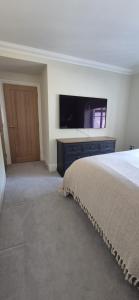 a bedroom with a bed and a flat screen tv at Marie House in Bowness-on-Windermere +14 photos