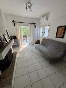 a living room with a bed and a tiled floor at Serene appartment at St. Ioannis in Agios Ioannis Pelio