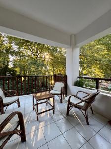 a porch with chairs and a table and windows at Serene appartment at St. Ioannis in Agios Ioannis Pelio