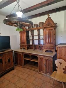 a kitchen with wooden cabinets and a television at Czereśniowy Dom dom na imprezy kawalerskie bunkry warsztaty in Goruńsko
