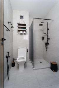 a bathroom with a shower with a toilet and a glass door at Transilvaniya Apartments in Sozopol +49 photos