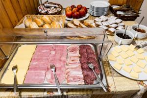 a table with meats and bread and other foods at Horská chata LADA in Loučná pod Klínovcem
