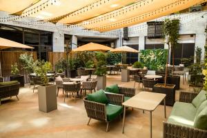 a restaurant with tables and chairs and umbrellas at Ramada Hotel & Suites by Wyndham Yerevan in Yerevan