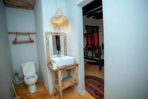 a bathroom with a sink and a mirror and a toilet at Peace House Zanzibar in Bwejuu +115 photos