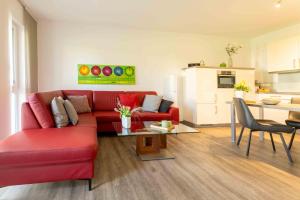 a living room with a red couch and a table at Ferienwohnung Kurpark in Xanten