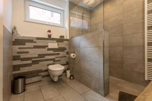 a bathroom with a toilet and a walk in shower at Ferienwohnung Kurpark in Xanten +41 photos