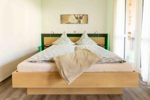 a bedroom with a large bed with a wooden headboard at Ferienwohnung Kurpark in Xanten