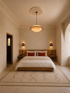 a bedroom with a large bed with a chandelier at TIZI Aït Ben Haddou in Aït Benhaddou