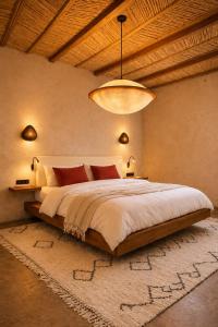 a bedroom with a large bed and a chandelier at TIZI Aït Ben Haddou in Aït Benhaddou