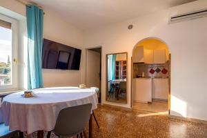 a dining room with a table and a kitchen at Apartment Di Lago by GardaDoma in Brenzone sul Garda +4 photos