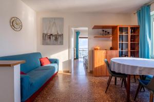 a living room with a blue couch and a table at Apartment Di Lago by GardaDoma in Brenzone sul Garda