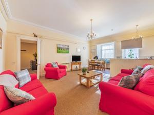 a living room with two red couches and a table at The Garden Apartment - Uk48320 in Berwick-Upon-Tweed