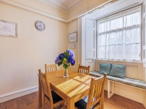 a dining room with a wooden table and a vase of flowers at The Garden Apartment - Uk48320 in Berwick-Upon-Tweed