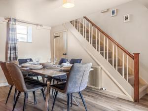 a dining room with a table and chairs and a staircase at Holme House in Halton Gill