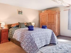 a bedroom with a bed with blue pillows on it at Holme House in Halton Gill
