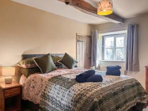 a bedroom with a bed with blue pillows on it at Holme House in Halton Gill +20 photos