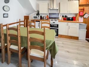 a kitchen with a table and chairs in a kitchen at 10 The Apostles - Uk37312 in Lochranza