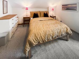 a bedroom with a bed and a dresser and two lamps at 10 The Apostles - Uk37312 in Lochranza
