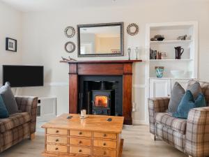 a living room with a fireplace and a mirror at 10 The Apostles - Uk37312 in Lochranza