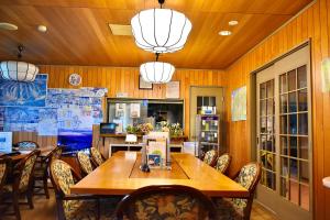 a dining room with a wooden table and chairs at Echoland Madarao エコーランド斑尾 All en-suite rooms & a free 3-minute shuttle to the ski resort in Madarao Kogen