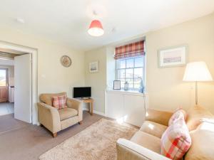 a living room with a couch and a chair and a television at South Lodge - Uk48318 in Berwick-Upon-Tweed