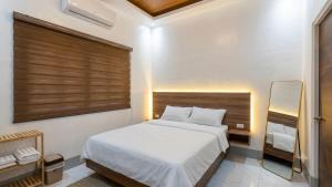 a bedroom with a white bed and a mirror at Urban Canopy City Forest Staycation in Tigbawan