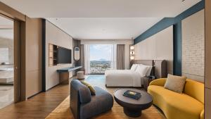 a hotel room with a king bed and a couch at voco Kuching by IHG in Kuching