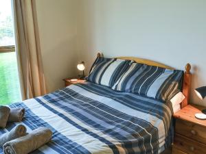 a bedroom with a blue and white bed with a window at Meadow Cottage - Uk45882 in Flamborough