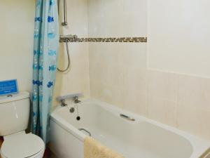 a bathroom with a tub and a toilet and a bath tub at Meadow Cottage - Uk45882 in Flamborough
