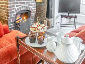 a table with a cake and a tea set on it at Hazel Cottage in Tolpuddle