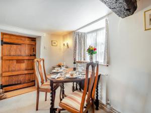 a dining room with a table and chairs at Hazel Cottage in Tolpuddle +12 photos