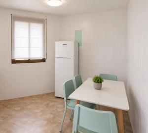 a kitchen with a table and chairs and a refrigerator at El Refugio de Navalcuervo 