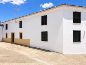 a white building with black barred windows on it at El Refugio de Navalcuervo 