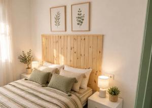 a bedroom with a bed with a wooden headboard at El Refugio de Navalcuervo  +15 photos