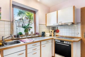 a kitchen with white cabinets and a sink and a window at Work&Travel-Pension Tobias in Selb
