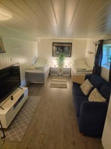 a living room with a couch and a tv at Sokkelleilighet rett ved Saltstraumen in Bodø +21 photos