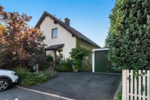 a house with a white fence and a driveway at Work&Travel-Pension Tobias in Selb