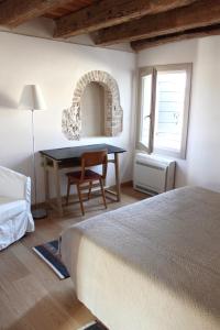 um quarto com uma cama, uma mesa e uma cadeira em Caspineda Agriturismo em Montebelluna