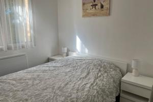 a white bedroom with a bed and two night stands at Flat With Swimming Pool Close To The Beach in Arcachon