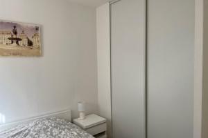 a bedroom with a bed and a glass closet at Flat With Swimming Pool Close To The Beach in Arcachon