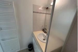 a white bathroom with a sink and a mirror at Flat With Swimming Pool Close To The Beach in Arcachon +4 photos