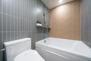 a bathroom with a white toilet and a bath tub at Just Stay Hotel in Seoul