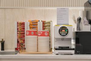 a stack of plates next to a food scale on a counter at Just Stay Hotel in Seoul +24 photos