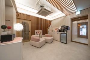 a living room with two chairs and a kitchen at Just Stay Hotel in Seoul