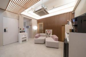 a living room with two chairs and a couch at Just Stay Hotel in Seoul