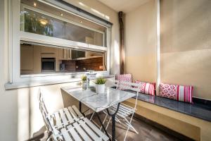 a dining room with a table and chairs and a window at Apartment Das Goldgassl in Appiano sulla Strada del Vino