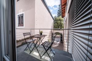 a balcony with two chairs and a table at Apartment Das Goldgassl in Appiano sulla Strada del Vino +32 photos